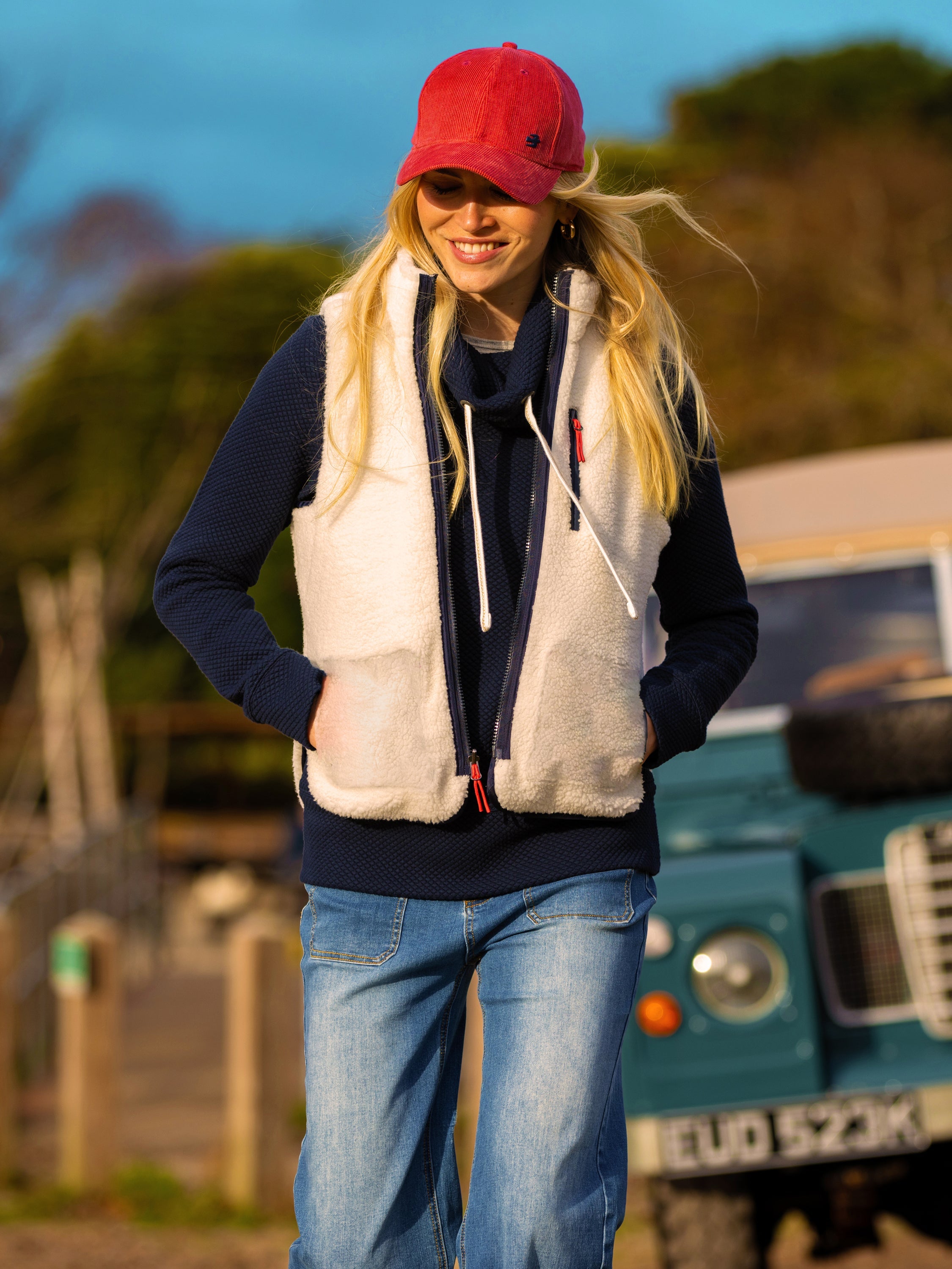 Female model wearing a Brakeburn gilet on a midday beach walk.