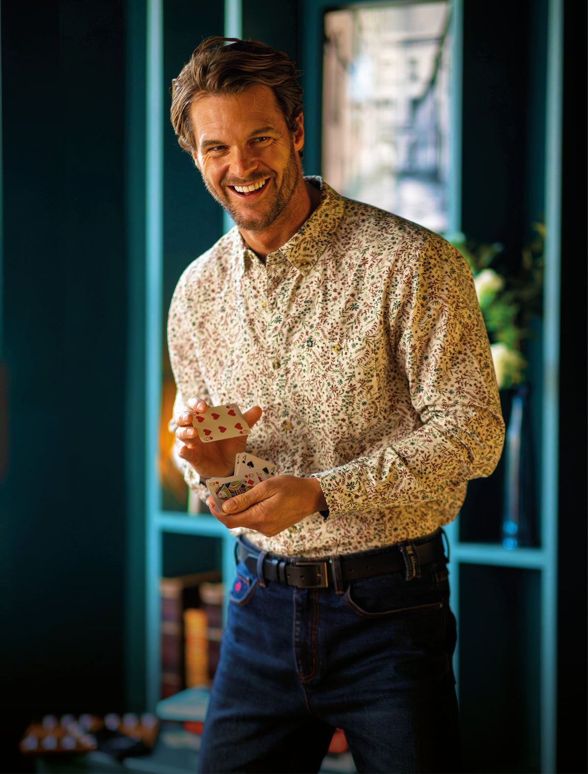 Man in shirt and jeans shuffling cards - shop new mens shirts