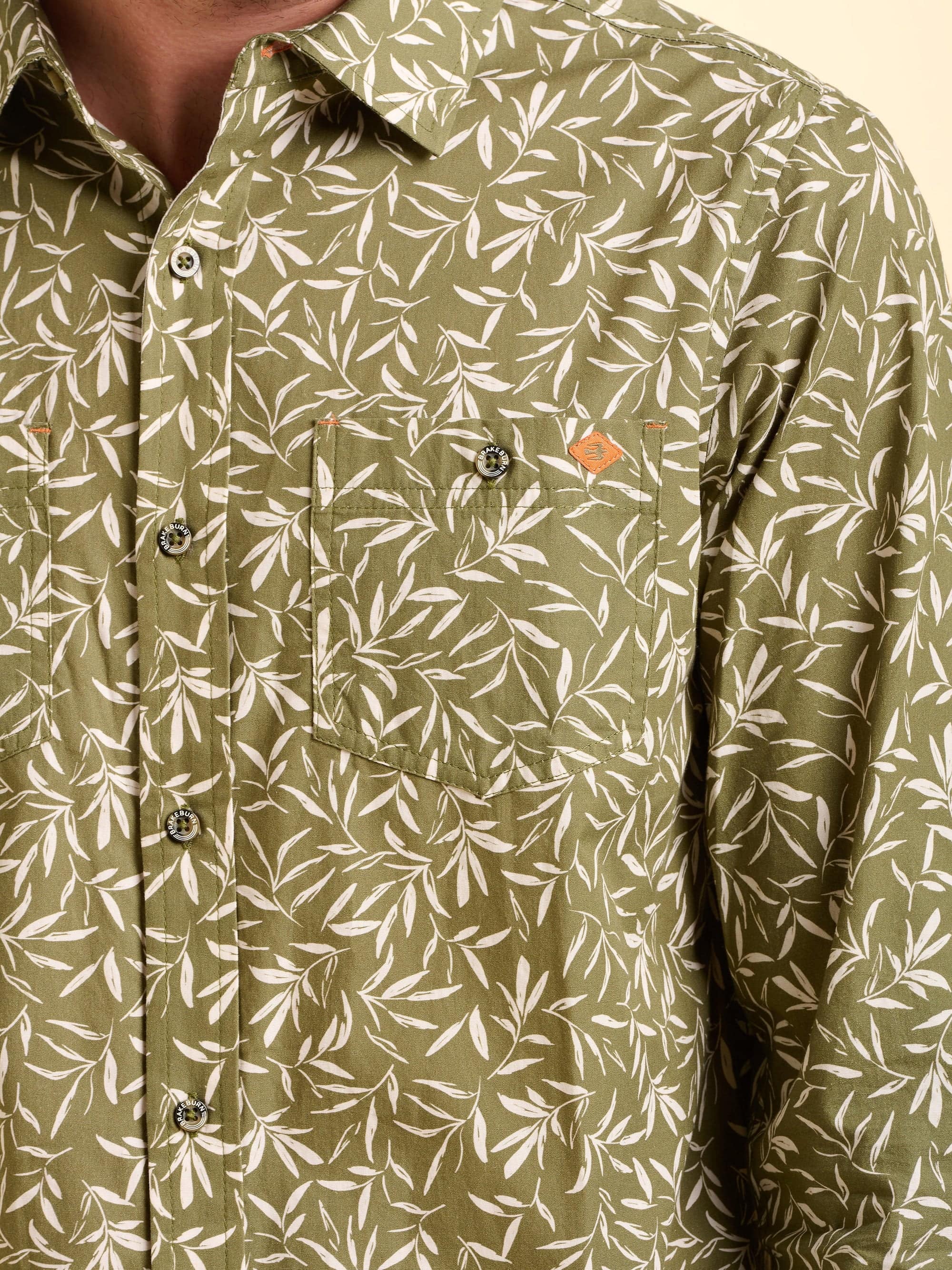 Close-up of the green bellshill shirt with white leaf pattern worn by a man.