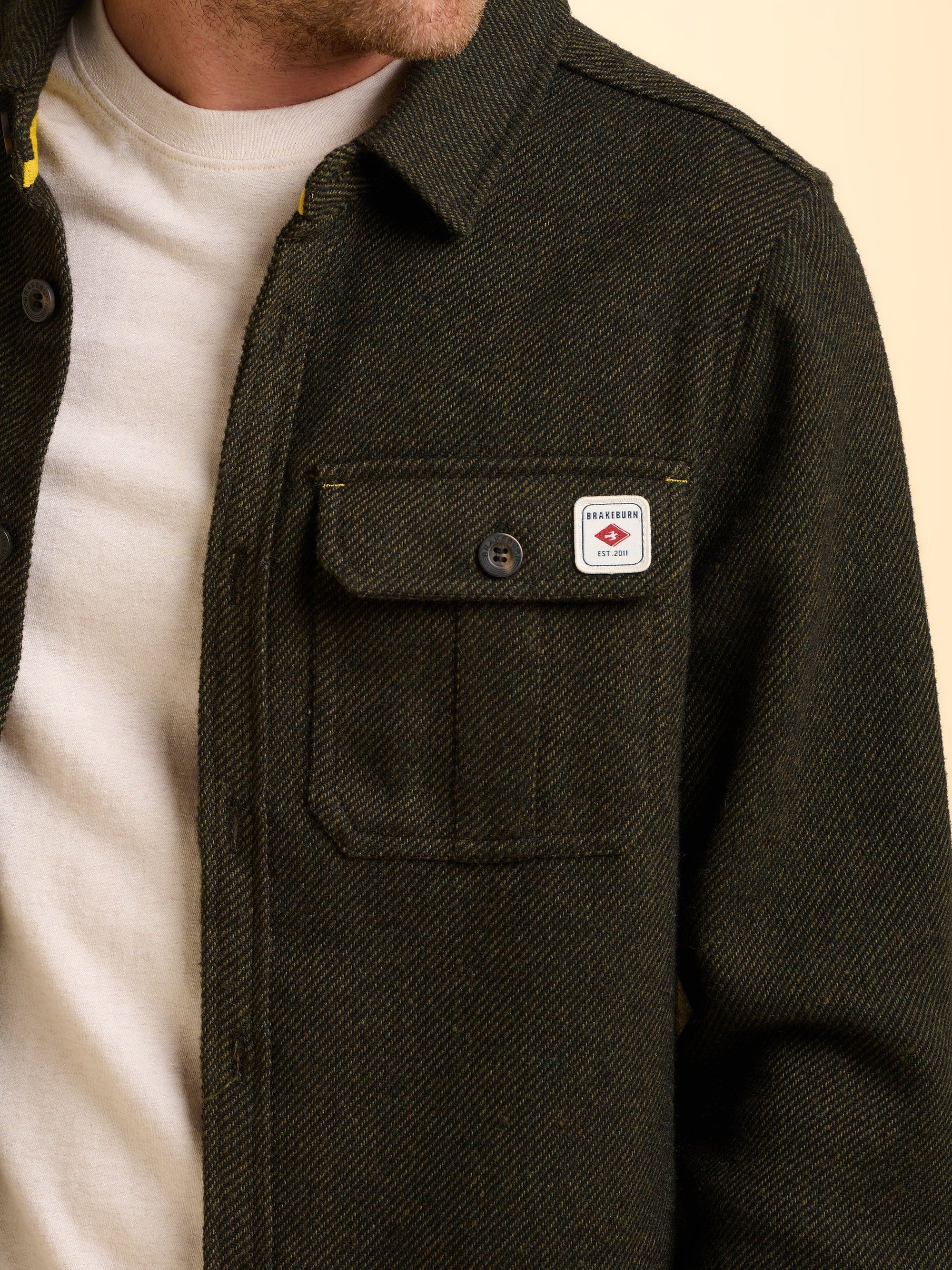 Dark green jacket with a Brakeburn logo on the chest pocket.