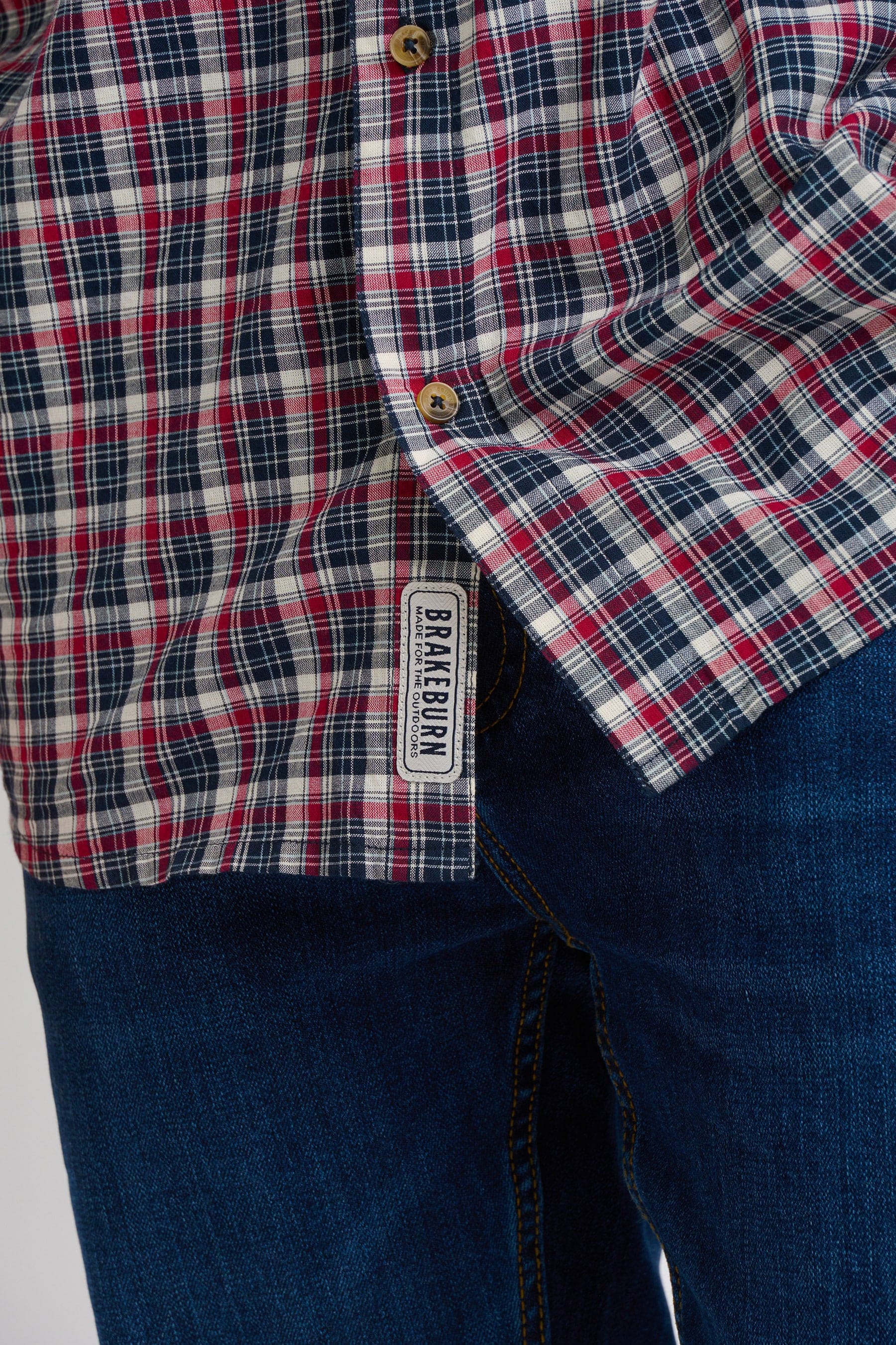 Close-up of a red and navy blue plaid check shirt with a Brakeburn label sewn in
