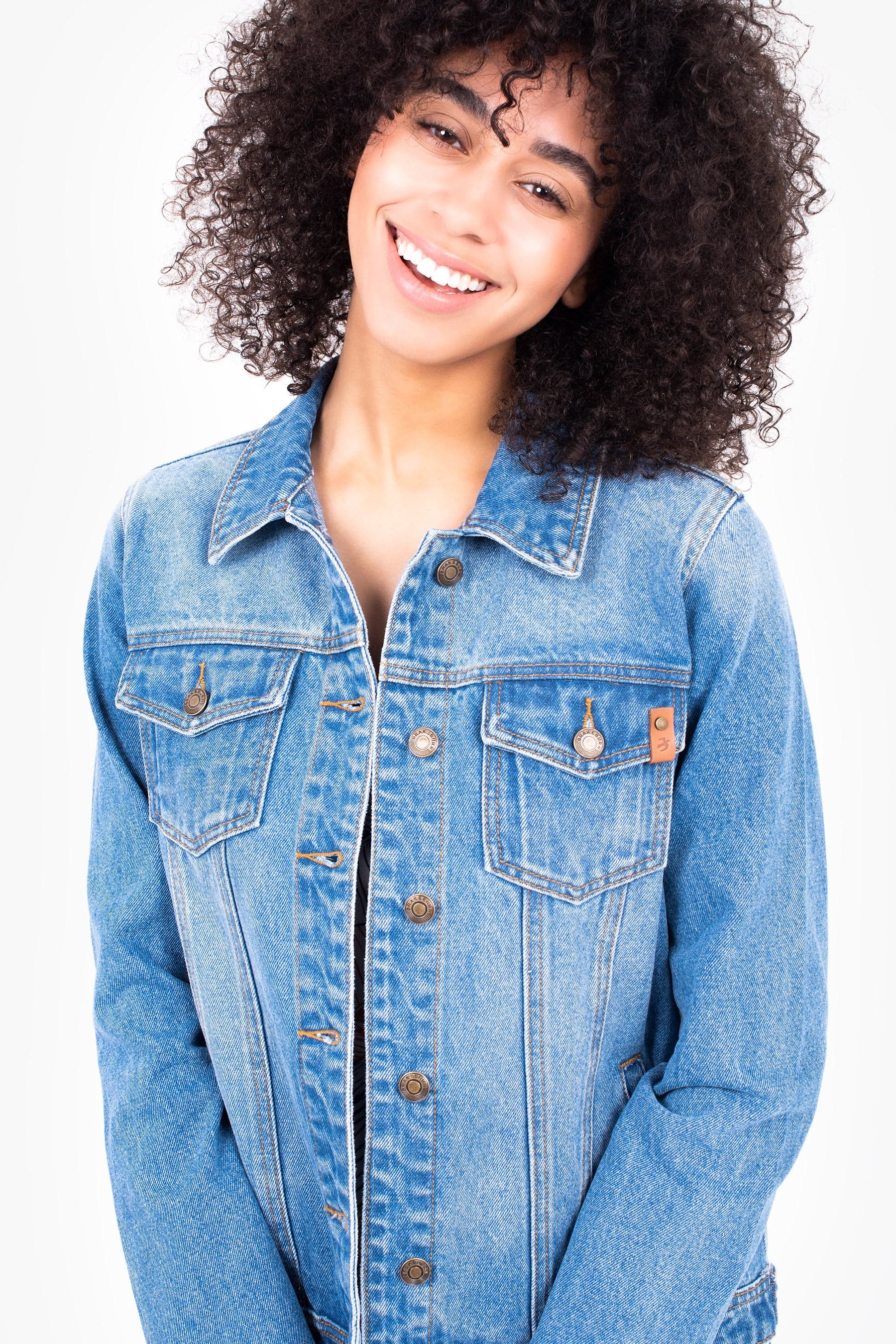 Model wearing a blue denim jacket in front of a white background.