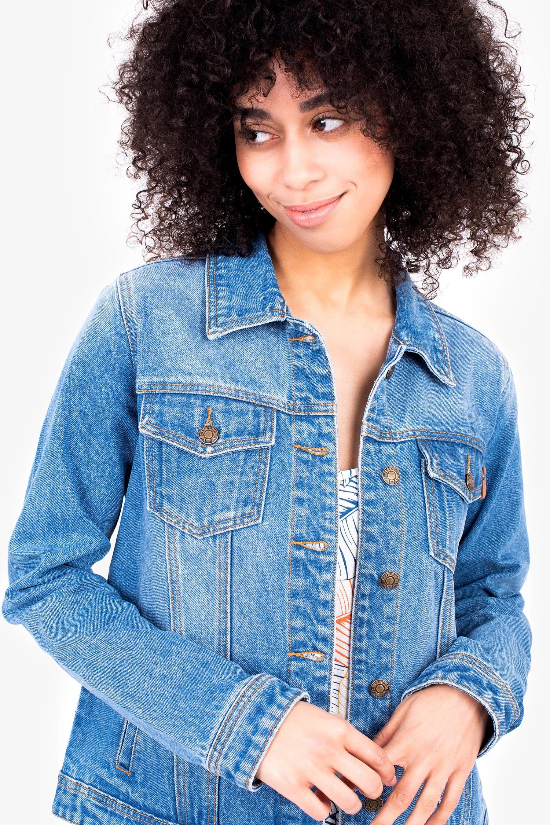 Woman wearing the blue everyday denim jacket with a white background.
